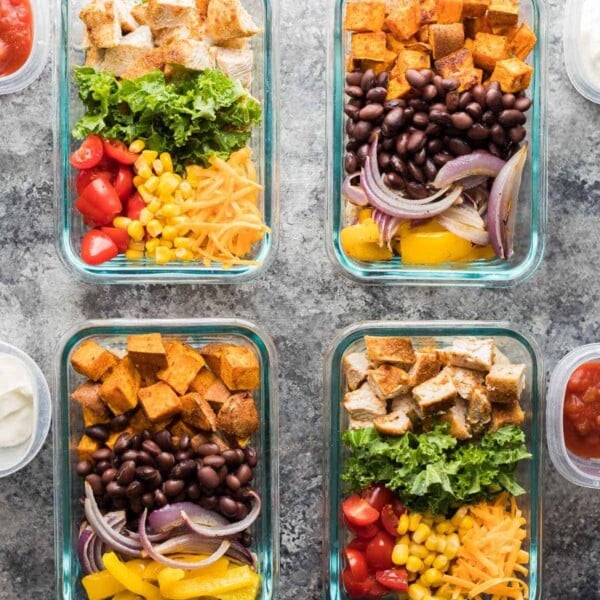 overhead shot of four glass meal prep containers with mix and match burrito bowls
