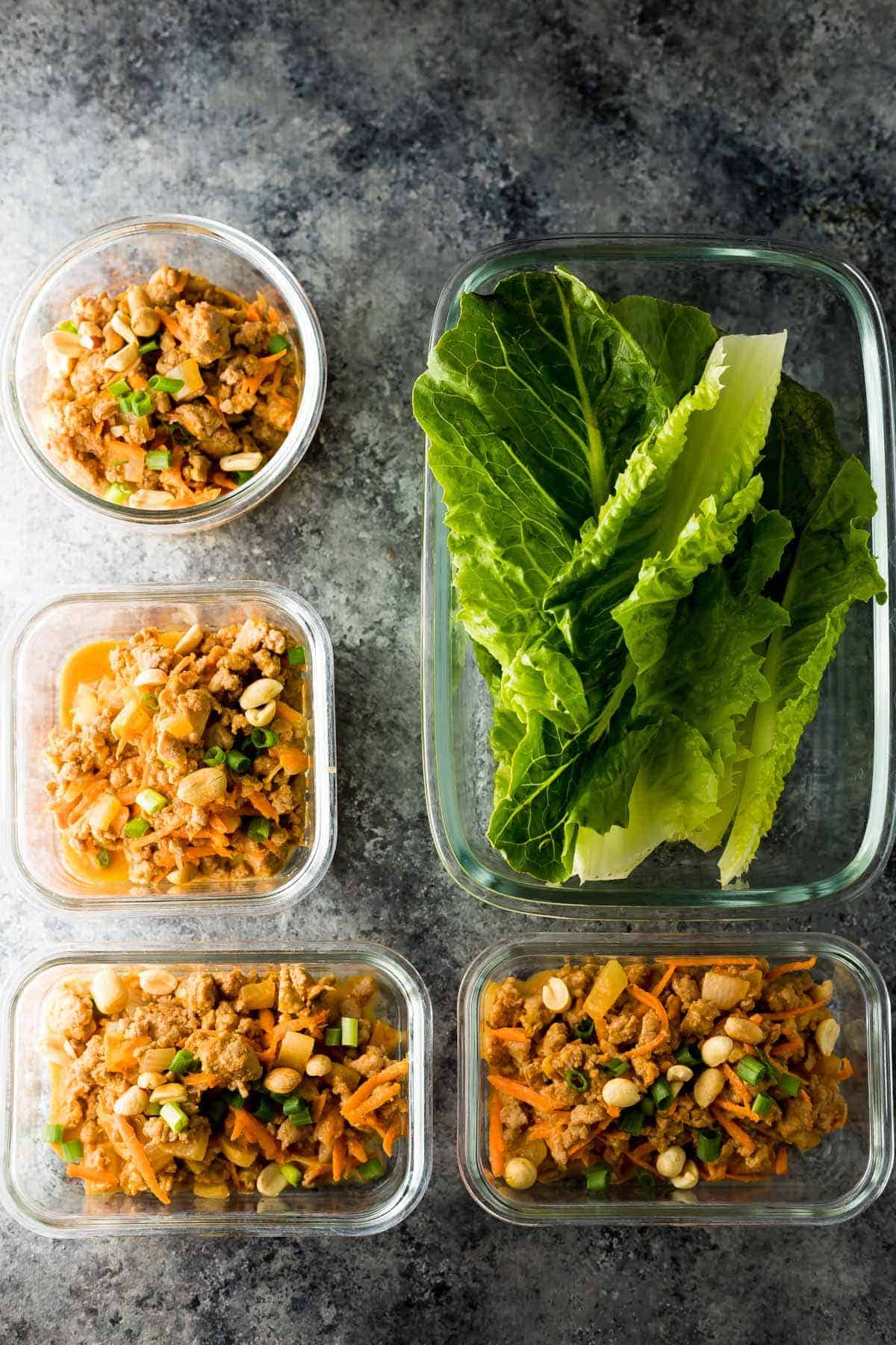 Ground turkey filling and romaine lettuce leaves in meal prep containers for thai turkey lettuce wrap recipe