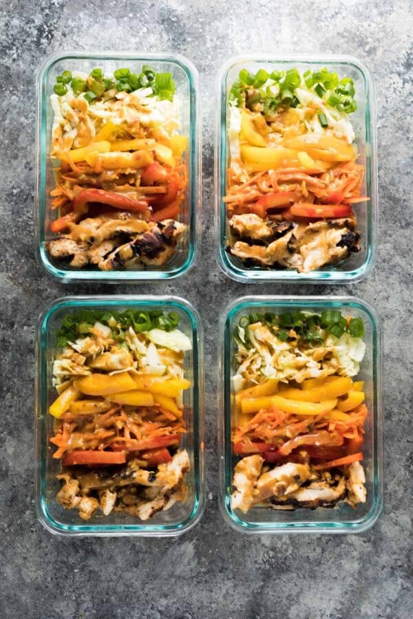 overhead shot of four satay chicken meal prep lunch bowls
