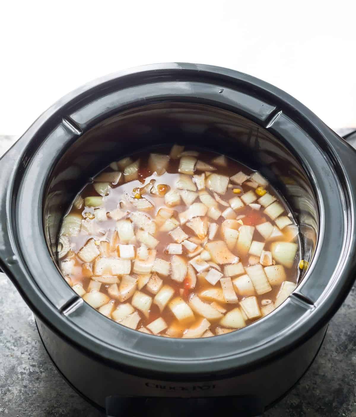 Slow cooker with broth and vegetables