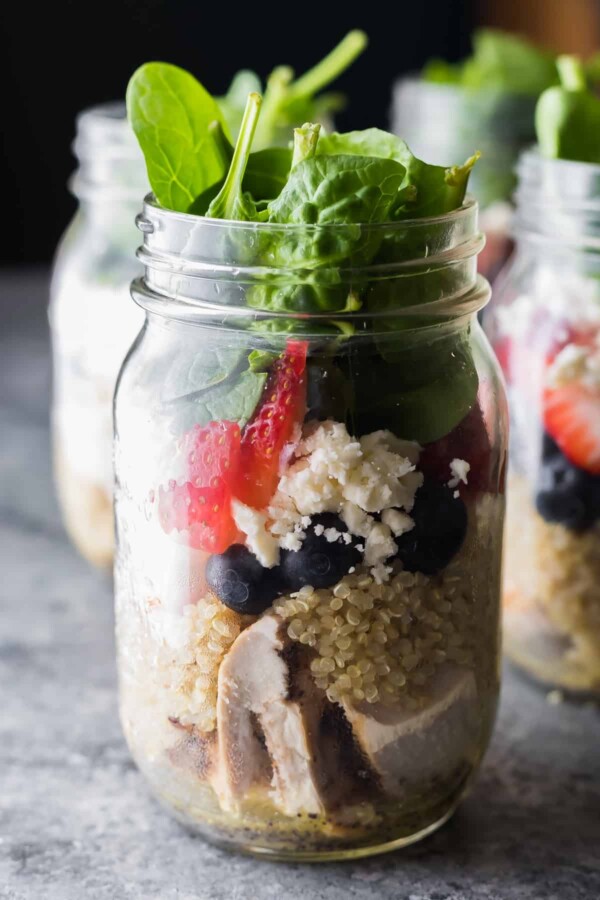 Strawberry Spinach Quinoa Salad in four glass mason jars