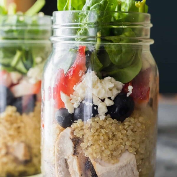 close up of a mason jar with strawberry spinach quinoa jar salad