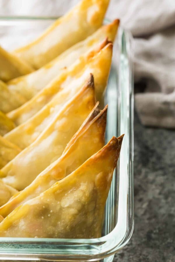 baked cauliflower chickpea samosas in a row in glass baking pan
