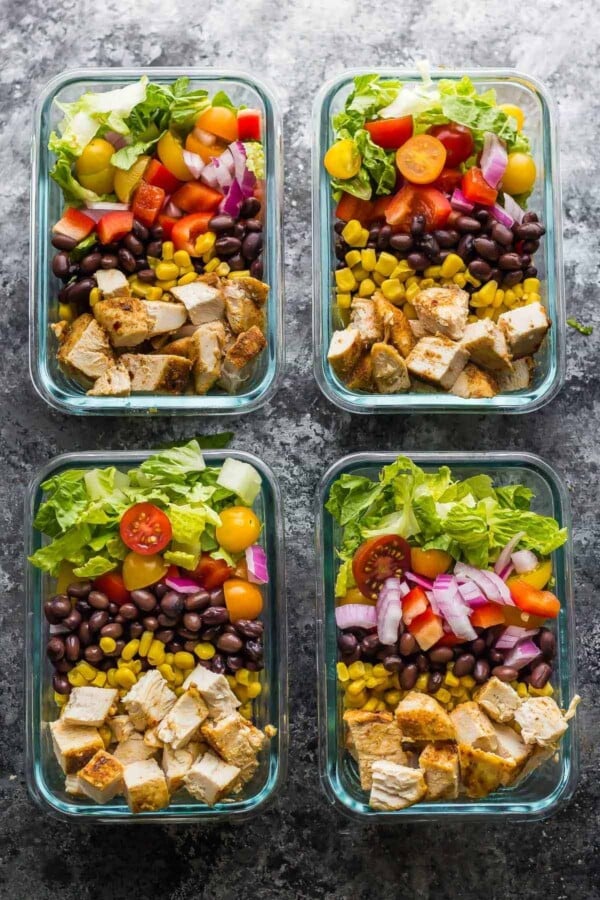 overhead shot of four glass meal prep containers filled with southwestern chopped chicken salad