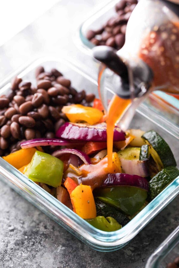 Grilled Veggie and Black Bean bowl with barbecue dressing being poured over top