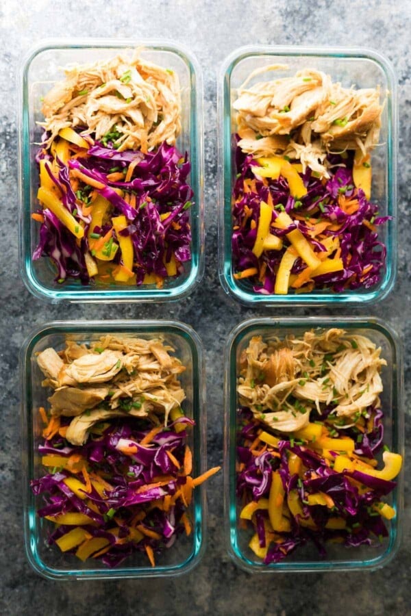 overhead shot of four glass containers filled with chipotle honey chicken taco salad bowls