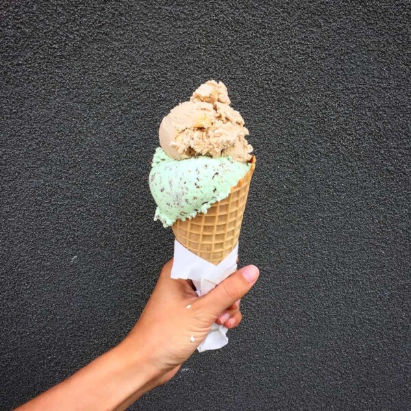 a hand holding up a large ice cream cone