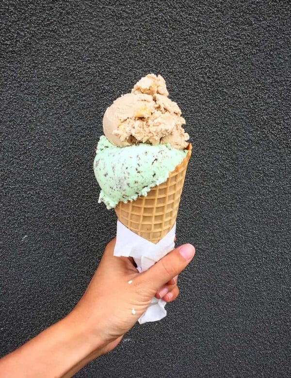 hand holding up a a large icecream cone