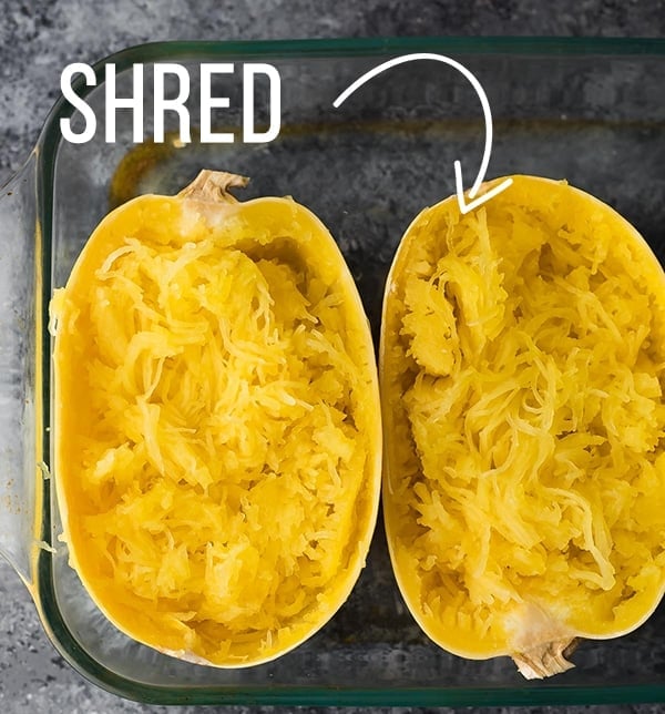 Spaghetti squash in baking dish after baking with flesh shredded