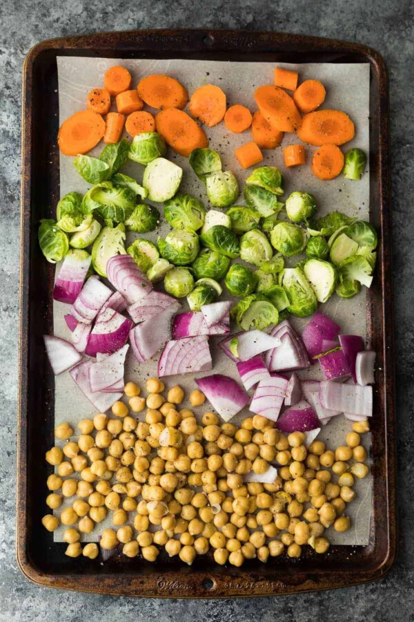 chickpeas, red onion, brussel sprouts, carrots on sheet pan before baking