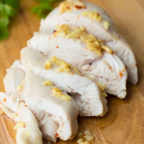sliced ginger and lemon chicken on wood cutting board