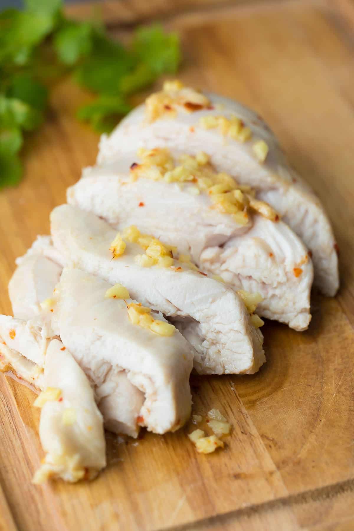 Ginger and lemon chicken marinade on sliced chicken on cutting board