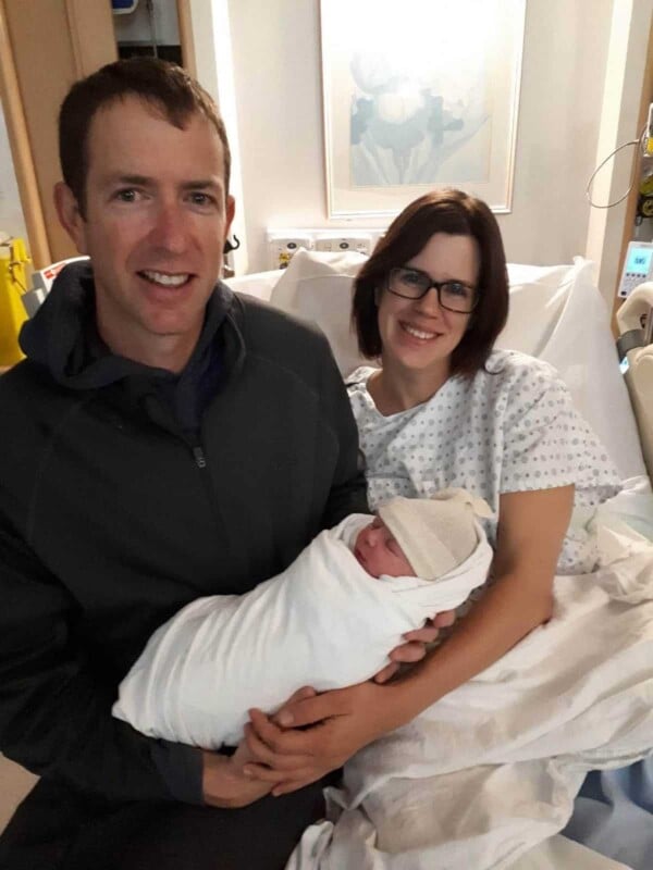 Denise and her husband with a small baby in a hospital bed