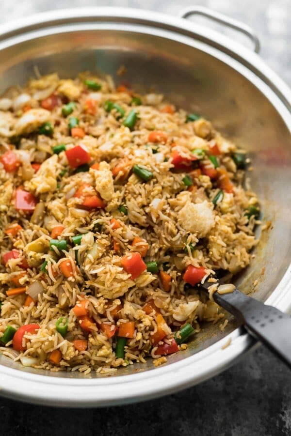 Fried rice in a large wok with spatula