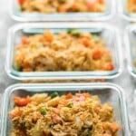 row of glass meal prep containers filled with egg fried rice