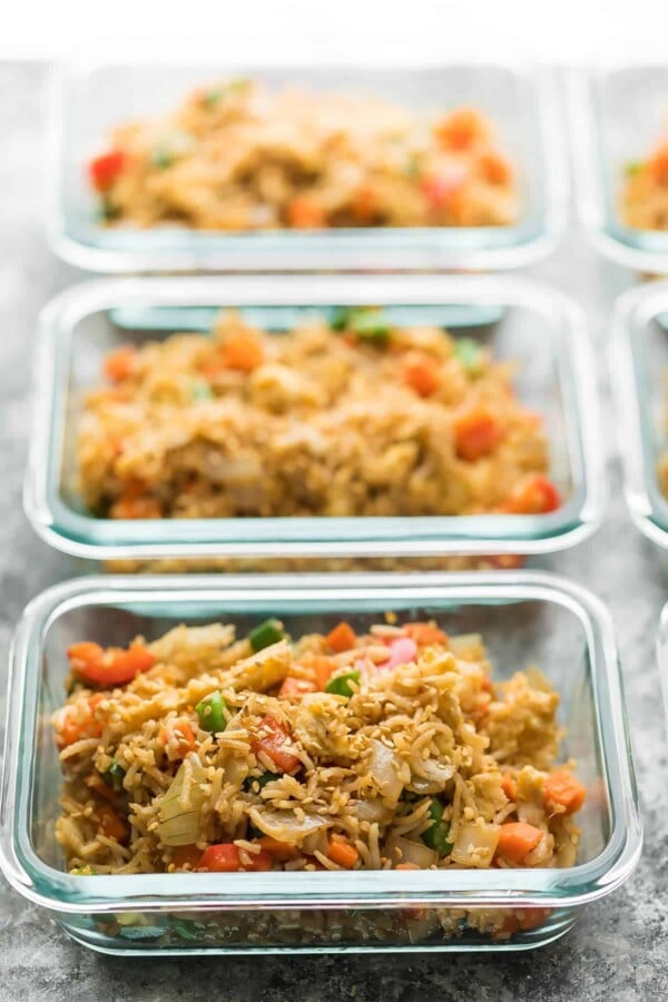 a line of glass meal prep containers filled with fried rice