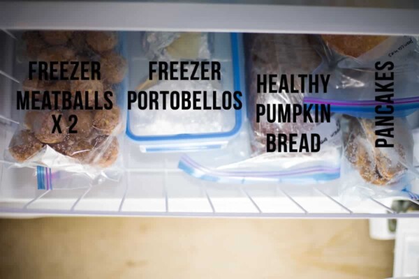 Photo of ziploc bags and meal prep containers inside freezer with text freezer meatballs, freezer portobellos, healthy pumpkin bread, and pancakes