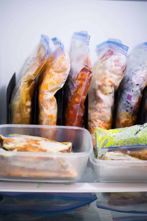 Close up view of ziploc bags full of freezer meals organized inside freezer