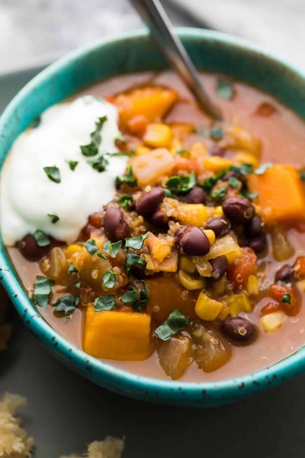 close up shot of black bean quinoa sweet potato stew in blue bowl