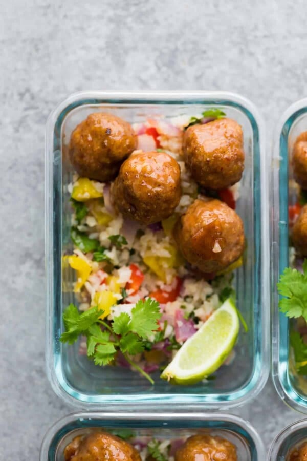 Overhead view of glass meal prep container with honey chipotle meatballs and cilantro lime cauliflower rice