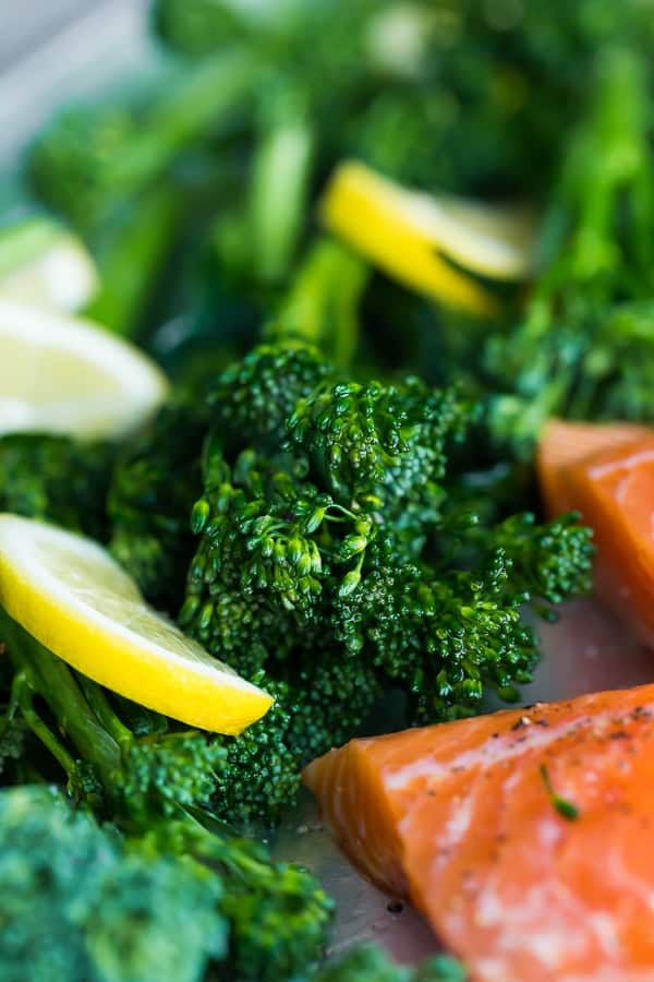  Close up shot of broccoli with lemon wedges and a corner of the salmon