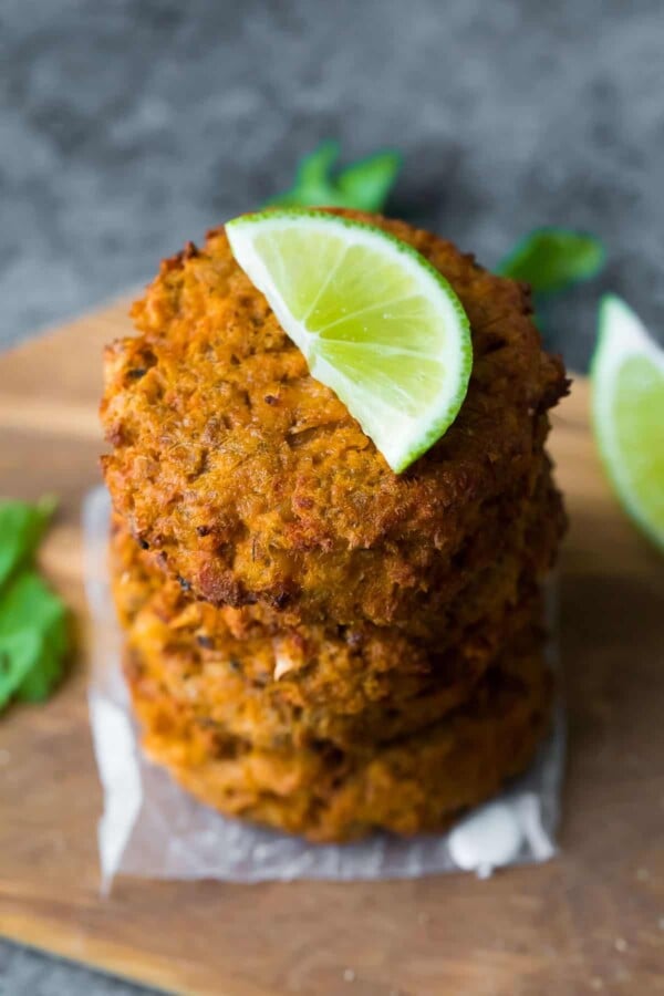 Make Ahead Thai Salmon Patties stacked on cutting board with lime wedge