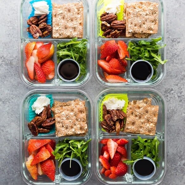 overhead shot of four spring strawberry bento boxes on gray counter