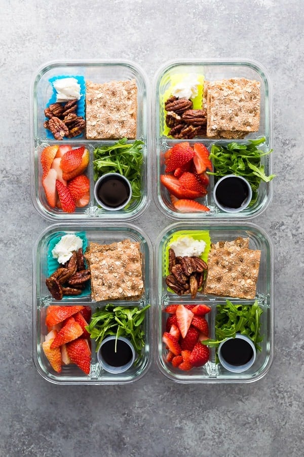 overhead shot of four Spring strawberry bento lunch boxes in glass meal prep containers