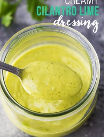 Close up shot of creamy cilantro lime dressing in a glass mason jar with a spoon