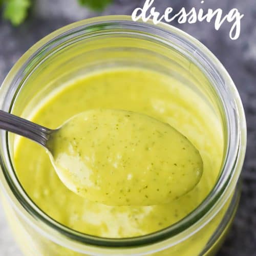 Close up shot of creamy cilantro lime dressing in a glass mason jar with a spoon