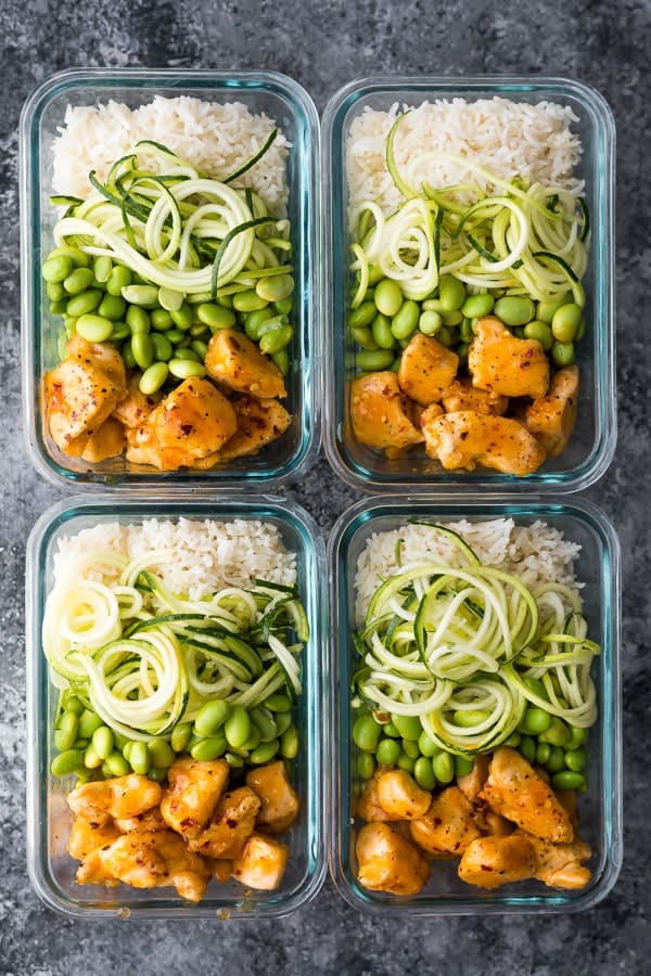 overhead shot of four firecracker chicken meal prep bowls