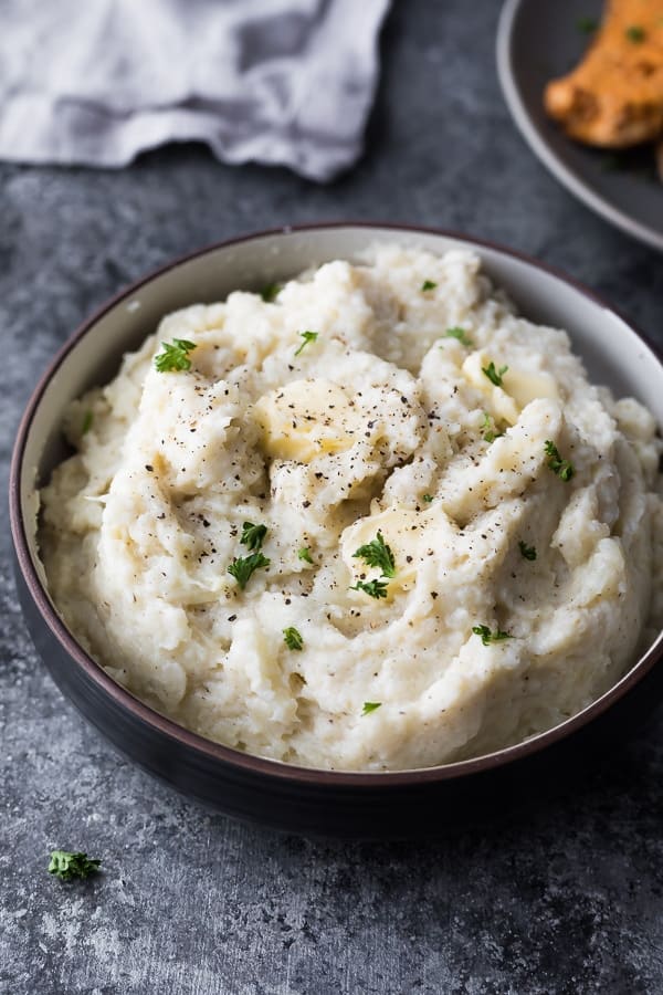 Bowl of creamy mashed cauliflower with butter and herbs