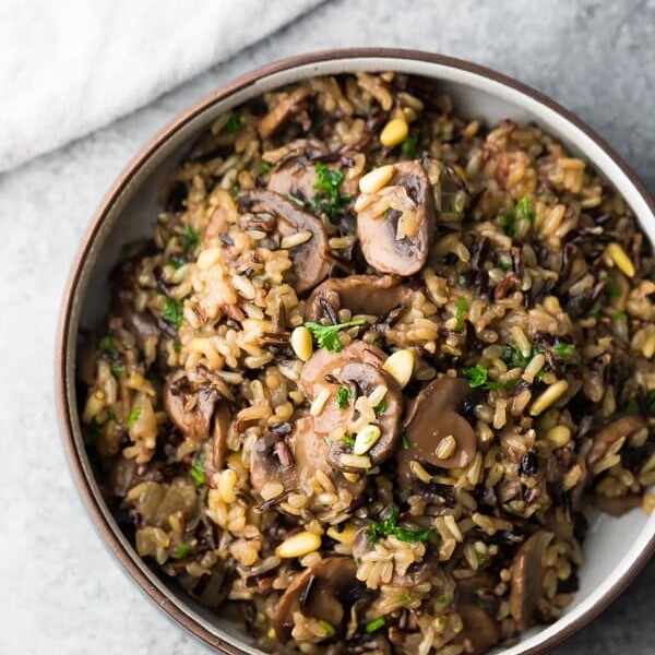 overhead shot of wild rice pilaf in brown bowl sitting on gray counter