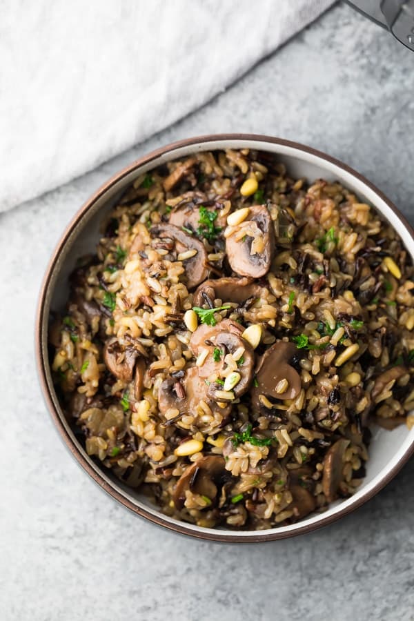 Instant Pot Wild Rice and Mushroom Pilaf with Pine Nuts in brown bowl