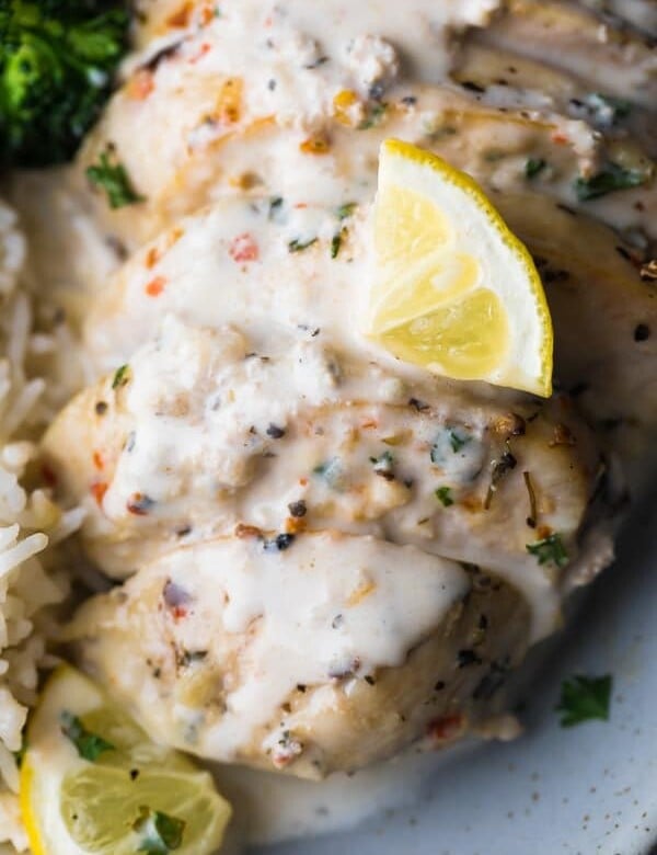 closeup shot of creamy lemon chicken breasts with a lemon slice