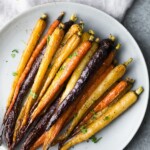 Multi-colored honey roasted carrots on a white plate