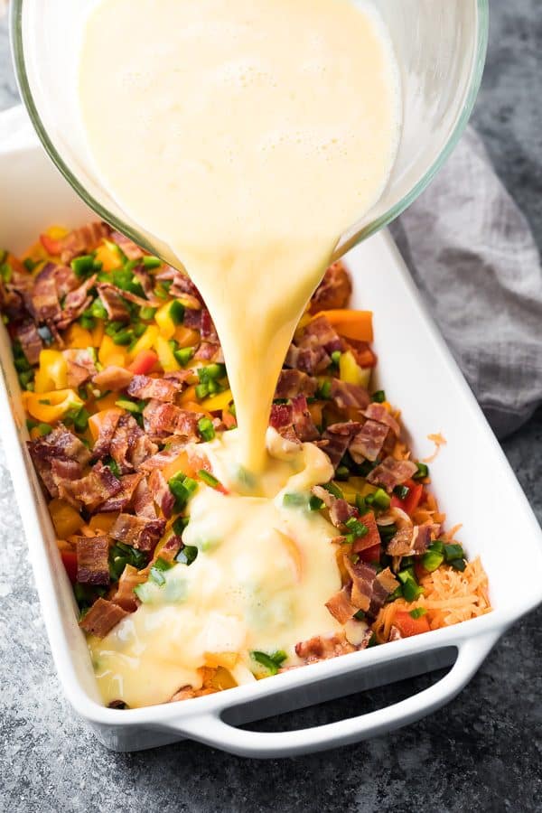 close up shot of breakfast casserole with bacon and sweet potatoes in white casserole dish