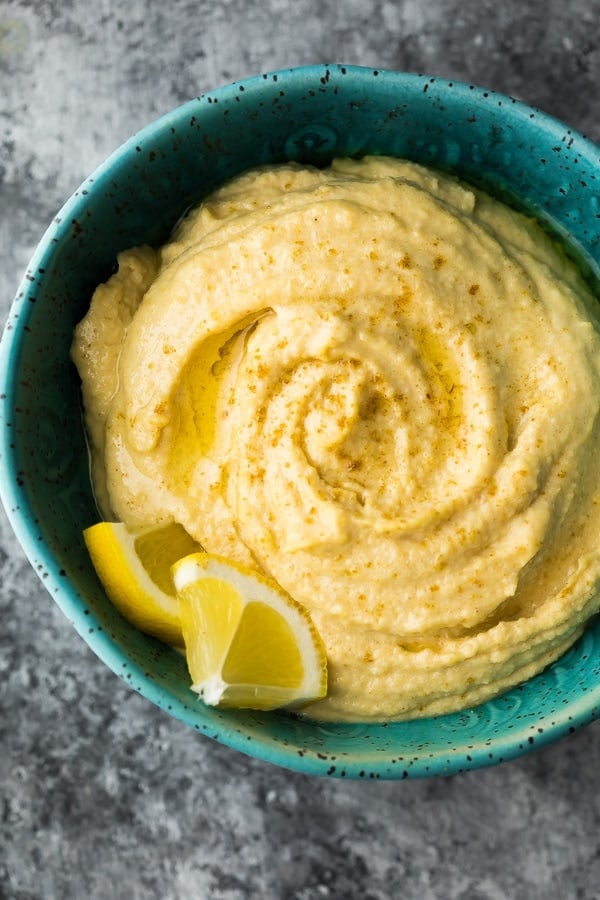 overhead close up shot of hummus in bowl with lemon slices