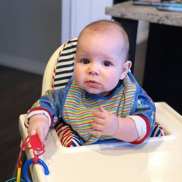 Denise\'s baby sitting in a high chair