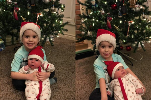 two little boys wearing santa hats in front of a christmas tree