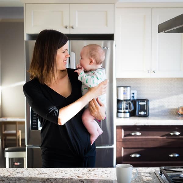 Denise standing in the kitchen with her baby