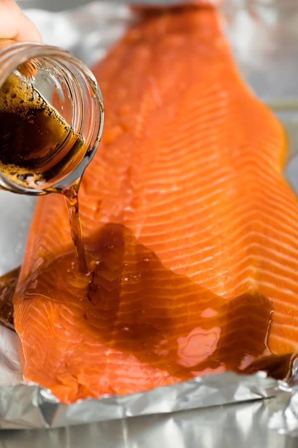 pouring the maple soy marinade over the salmon