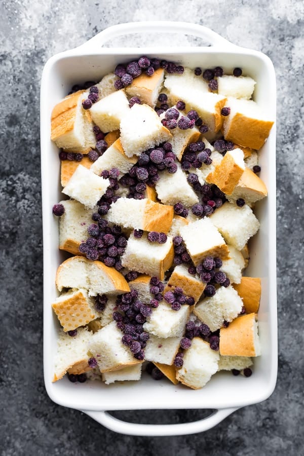 bread and blueberries in a baking dish for the Blueberry Overnight French Toast casserole