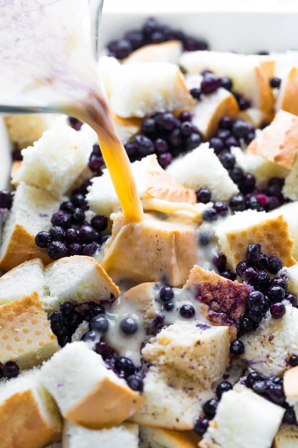 pouring milk onto the overnight blueberry french toast