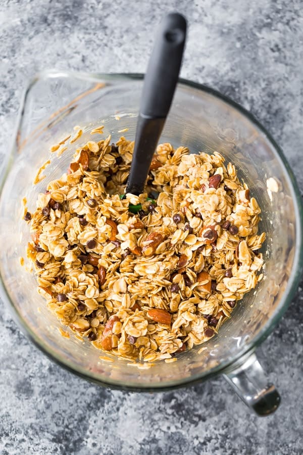 rolled oats, almonds, chocolate chips and granola bar ingredients in large glass mixing bowl from above