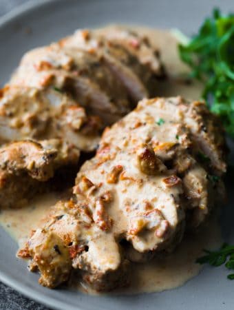 close up shot of chicken breasts sliced with sun dried tomato cream sauce