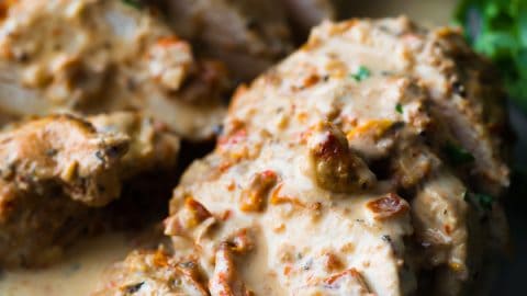 close up shot of chicken breasts sliced with sun dried tomato cream sauce