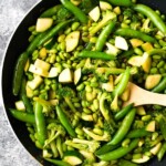 ginger teriyaki stir fry with broccoli snap peas and greens in skillet with wood spoon