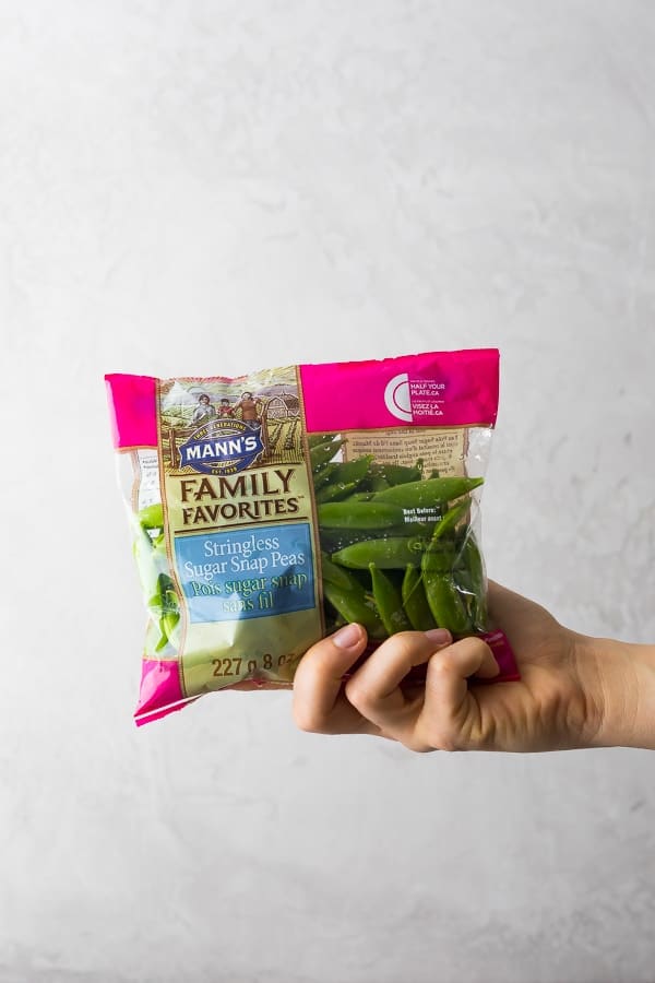 hand holding bag of stringless sugar snap peas