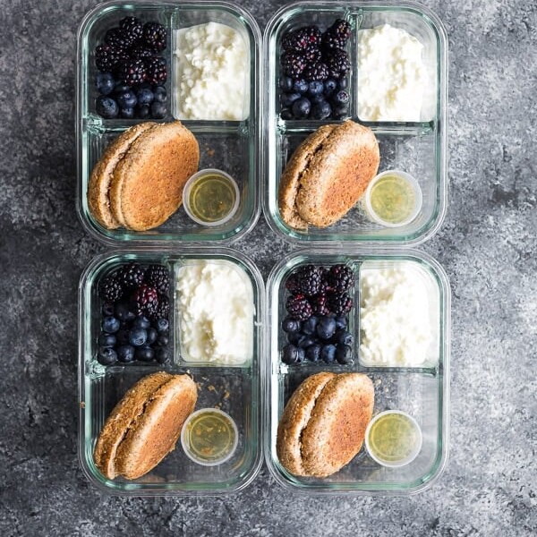overhead shot of four english muffin breakfast bento boxes on gray background